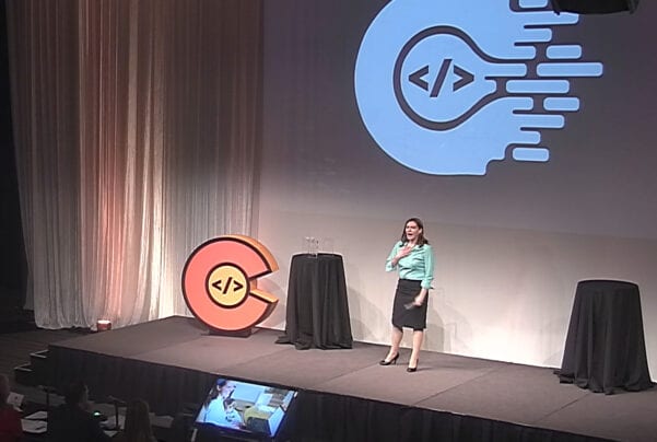 Amber standing on stage with Go Code Colorado emblem - cramer looking down from a distance
