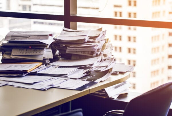 giant stacks of paperwork on desk in urban office building