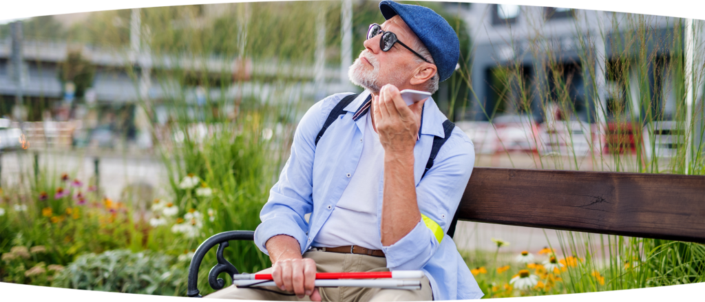 blind man with cane listening to his mobile phone