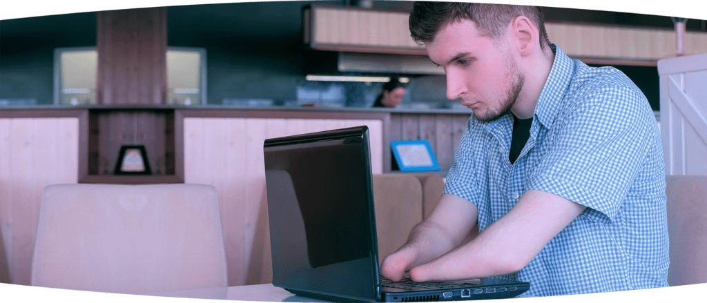 young man with amputated hands using a laptop in a diner