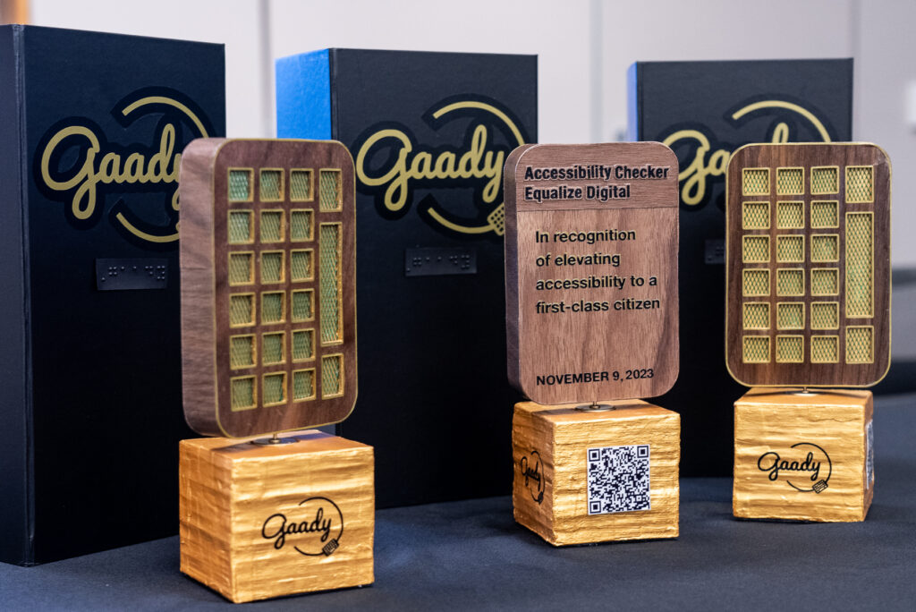 Three GAADY award trophies on a table.